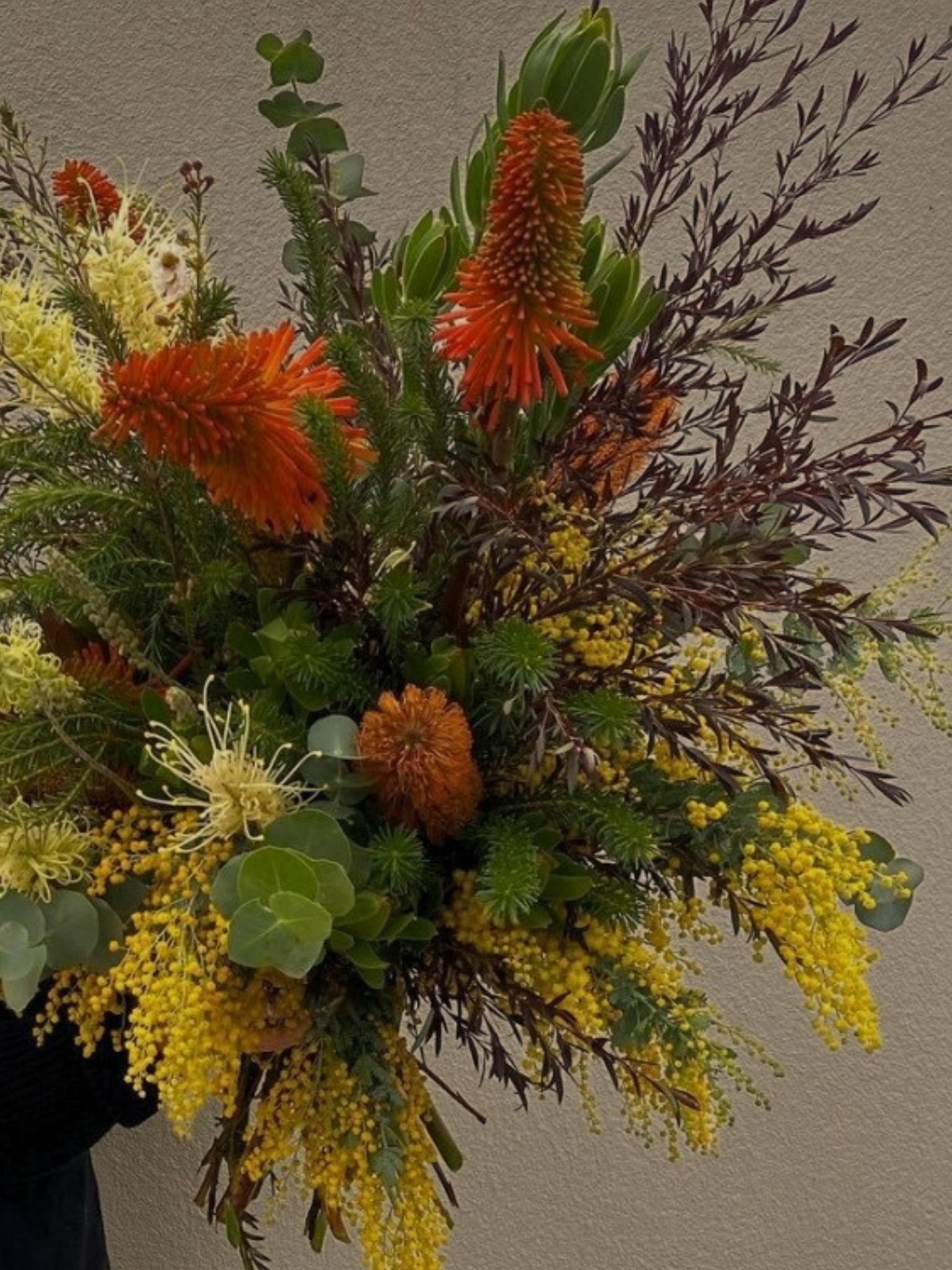 Festive Christmas floral arrangement with seasonal gift items