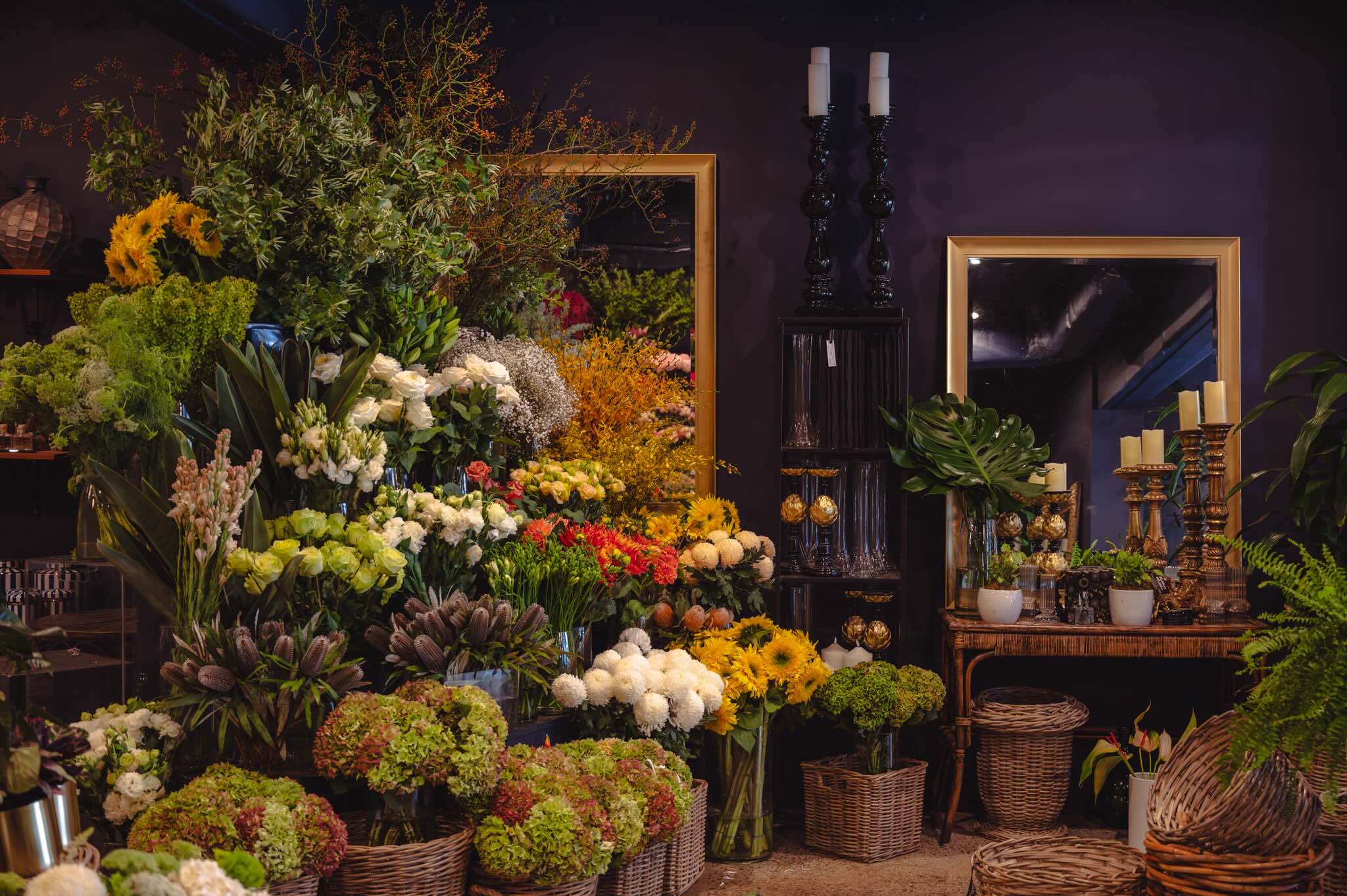Floral arrangements in a store with decorative elements and mirrors.