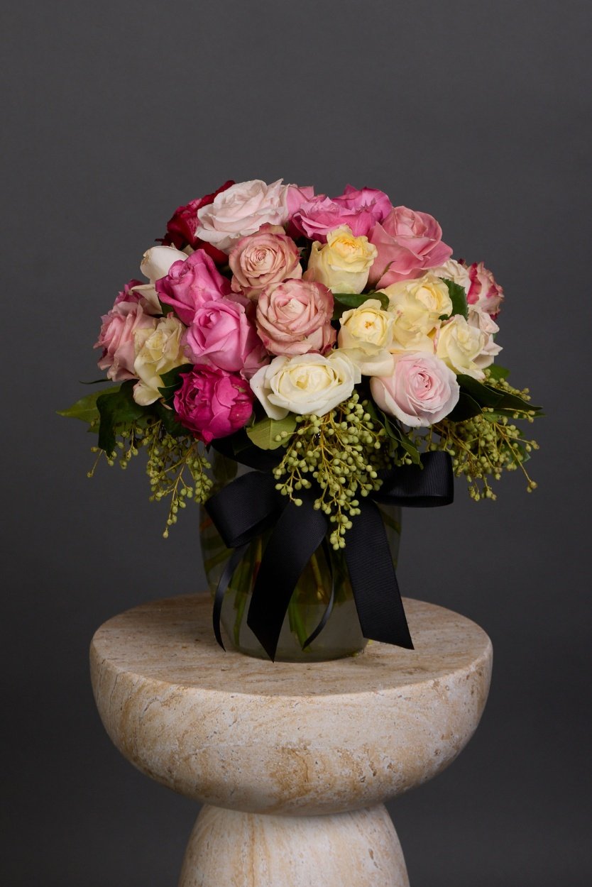 A delightfully classic and timeless bouquet of soft to mid toned medium length roses accompanied by luscious foliages