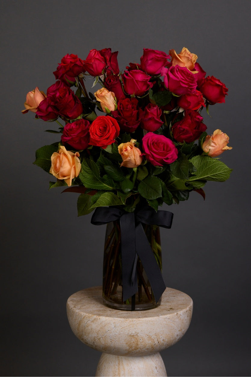 Vibrance bouquet featuring sunset-hued roses with rich seasonal foliage