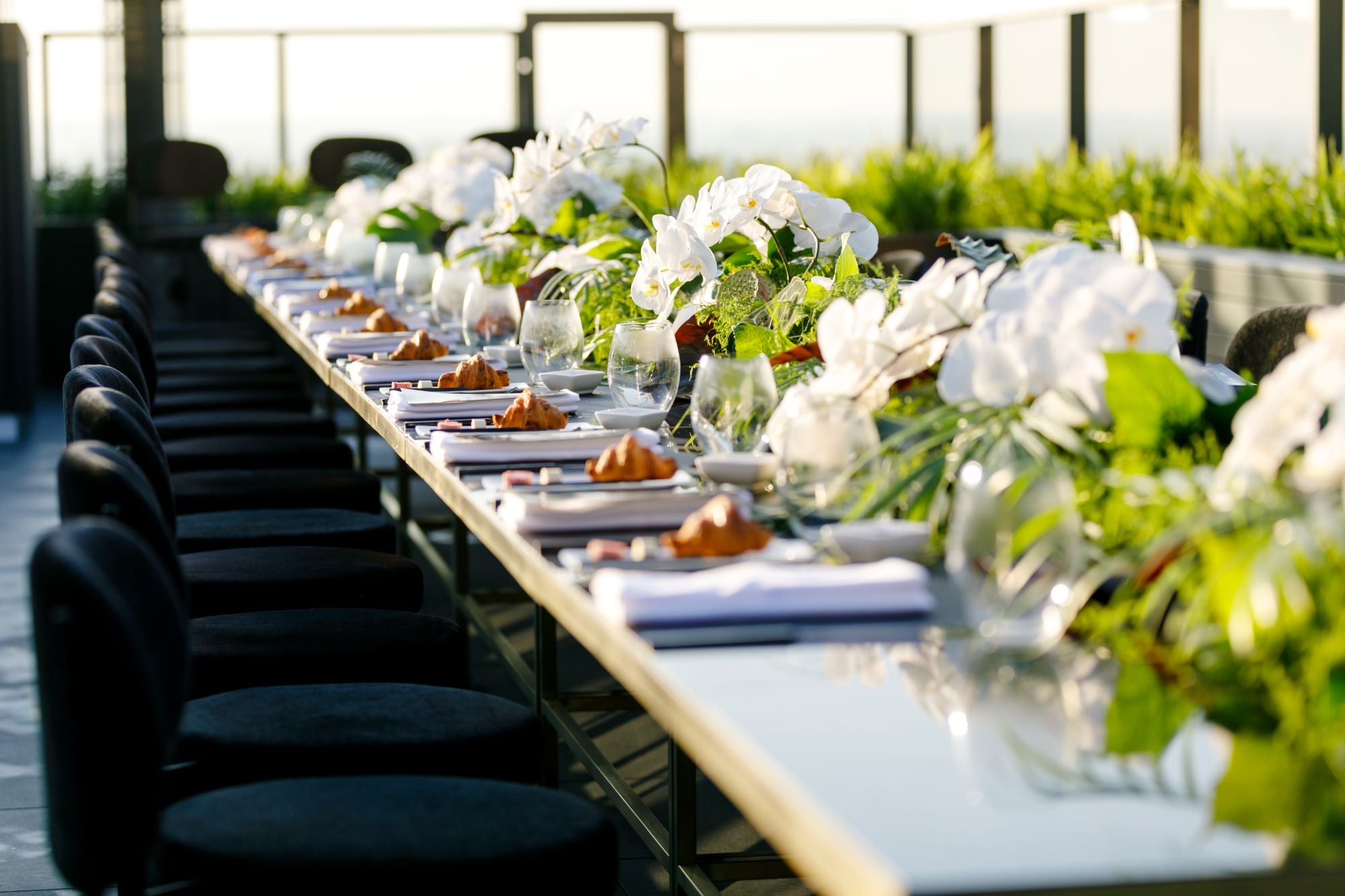Elegant table setting styled with seasonal florals, orchids, and fine glassware—Victoria Whitelaw private event flowers.
